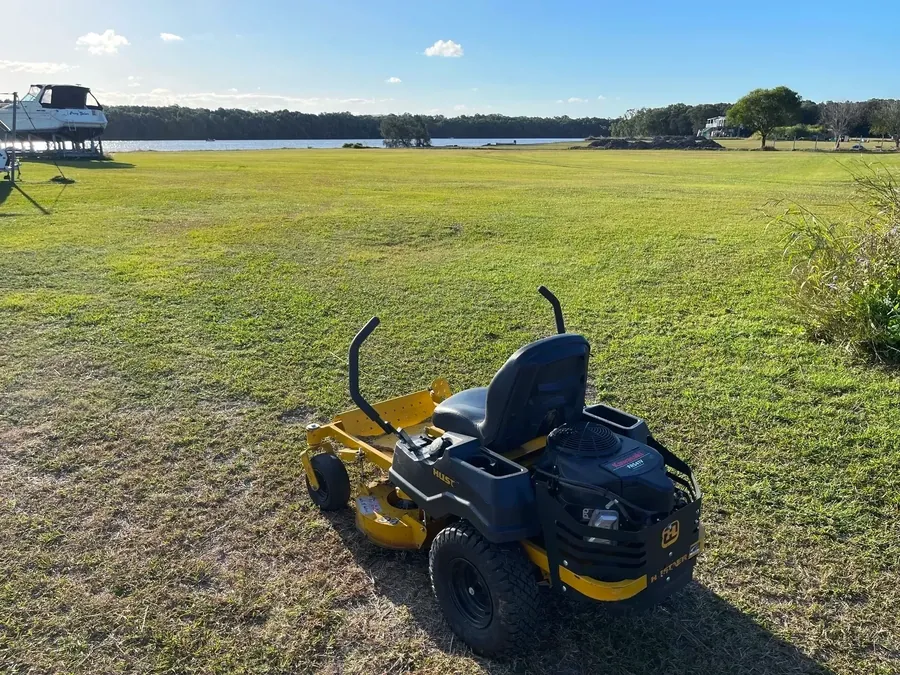 Zero-turn ride-on on a large mown riverside block — acreage mowing Gold Coast